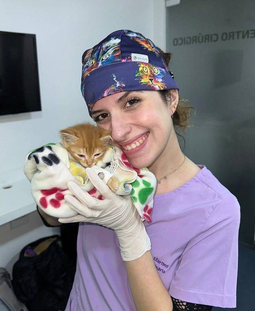 Raphaella Martins segurando um filhote de gato enrolado em uma mantinha