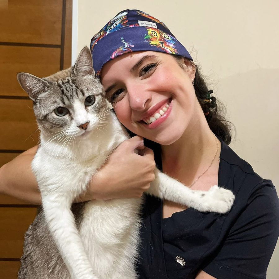 Raphaella Martins, médica veterinária, abraçando um gato